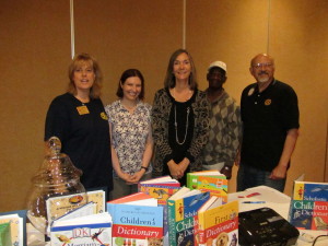 President Valles, Megan Brown, Laura Seaholm and Edi Birsan present a donation of dictionaries for the Project Second Chance program after the meeting.
